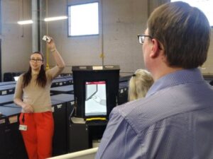 Luzerne County Acting Election Director Emily Cook holds a card needed to activate a ballot marking device during Monday’s mandatory public testing of voting equipment that will be used in the April 23 primary election. County Councilman Gregory S. Wolovich Jr. is at the right observing.
                                 Jennifer Learn-Andes|Times Leader