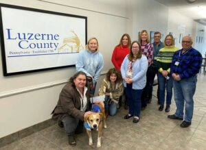 Luzerne County employees recently made a $460 donation to the SPCA of Luzerne County. The funds were raised when county employees were given the option of a Favorite Team Sports Jersey Dress-down Day in exchange for making a donation to the SPCA. From left: Romilda Crocamo, Luzerne County manager; Carol Amos, education and volunteer coordinator, SPCA of Luzerne County; Fred the dog; Nancy DeFluri, Luzerne County Controllers Office; Mary Roselle, Luzerne County division head, Budget and Finance; Aileen Adams, Luzerne County Controllers Office; Jennifer Thomas, executive assistant to the Luzerne County Manager; Thomas Sokola, Luzerne County Controllers Office; Michele Sparich, acting division head of operations, Luzerne County; Walter Griffith, Luzerne County controller.