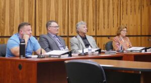Thick binders containing the proposed 2026 Luzerne County budget sit before council members during Tuesday’s meeting, when the administration’s recommended spending plan was formally presented. From left are four of the 11 council members: Jimmy Sabatino, Greg Wolovich, Chris Perry and Patty Krushnowski.
                                 Jennifer Learn-Andes | Times Leader